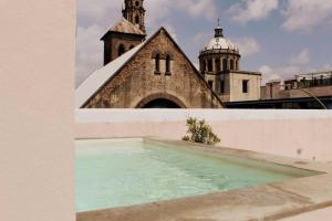 a church and a swimming pool in front of a building at Casa Alhaja - Diamante in Guadalajara