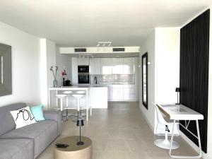 Una sala de estar con un sofá y una cocina. en Pure South Luxury Apartment, en Manilva