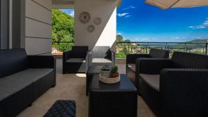 a balcony with couches and a view of the ocean at "LaGo Village House" Family & Group Retreat near Meteora in Kalabaka +22 photos