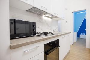 a kitchen with a stove and a microwave at Casa Vacanze ClaEli in Porto SantʼElpidio