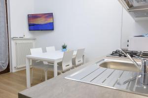 a kitchen with a white table and white chairs at Casa Vacanze ClaEli in Porto SantʼElpidio