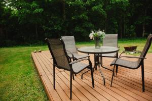 a table and four chairs on a wooden deck at Konrad Guesthouse in Kuressaare
