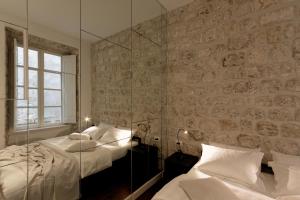 a hotel room with a bed and a mirror at Apartments Eleganca, crypto payment accepted in Dubrovnik