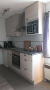 a kitchen with white cabinets and a microwave at Appartement Doesjes Huis in Naumburg +20 photos