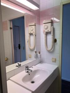 uma casa de banho com um lavatório branco e um espelho. em Hotell City Karlshamn em Karlshamn