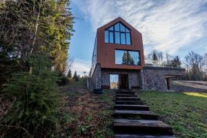 a house on a hill with stairs leading up to it at Valera Vita Forest House in Hlevci