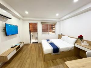 a hotel room with a bed and a tv at Home Away Ky Con - Serviced Apartment in Ho Chi Minh City