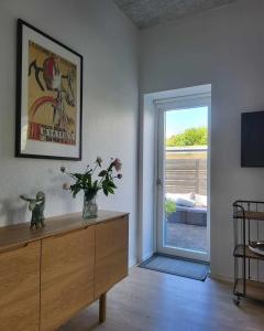 a living room with a wooden dresser and a sliding door at Modern & Homely Apartment - Free Parking in Viby