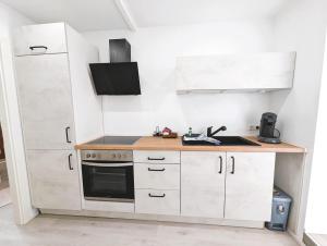a small kitchen with white cabinets and a stove at Apartment Nähe Airbus in Manching