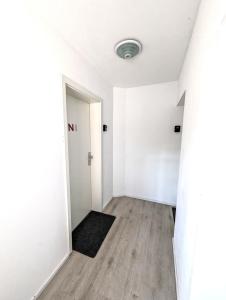 um quarto vazio com paredes brancas e pisos em madeira em Apartment Nähe Airbus em Manching