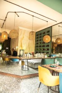 uma sala de jantar com mesas, cadeiras e lustres em The Blowfish Hotel em Lagos