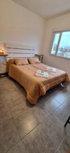 a large bed in a bedroom with a window at Departamento familiar in Caleta Olivia