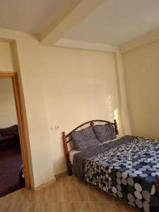 un dormitorio con una cama en una habitación en Calme et familial, en Saidia 