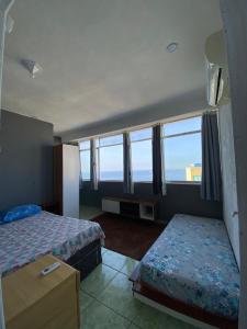 里約熱內盧的住宿－Hostel Alzira House Vidigal，一间带两张床的卧室,享有海景