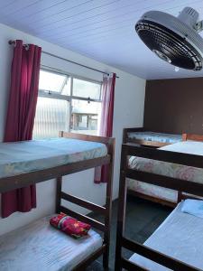 a room with three bunk beds and a window at Hostel Alzira House Vidigal in Rio de Janeiro