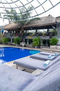 a swimming pool with two beds in a resort at The Blowfish Hotel in Lagos