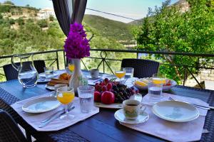 a table with plates of fruit and a vase of flowers at Villa Theodora in Kiónion