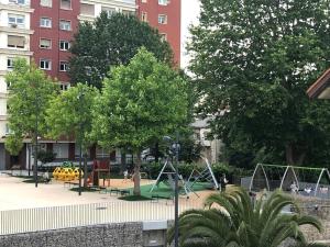 un parque con parque infantil con columpios y árboles en Apartamento turístico casaSali, en Santander