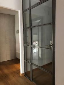 Una puerta de vidrio en una habitación con pasillo. en Apartamento turístico casaSali, en Santander