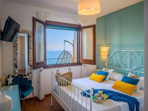 a bedroom with a crib and a large window at Borgo Eleatico in Casal Velino