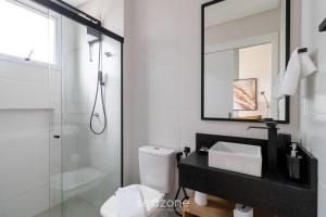 um banheiro com vaso sanitário, pia e espelho em Apartamentos próx a UFSC - SVE em Florianópolis mais 14 fotografias