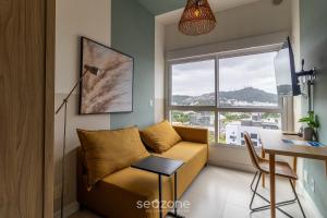 uma sala de estar com um sofá e uma mesa em Apartamentos próx a UFSC - SVE em Florianópolis