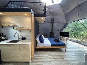 a bedroom in a tent with a bed and a sink at Natura in Saint Come