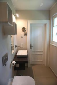 a bathroom with a toilet and a sink and a door at Haus Gipfel-Glück in Goslar