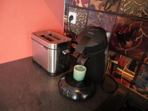 a coffee machine sitting on a counter with a cup at Au Gré des Saisons - Vulcania & Lemptégy in Pontgibaud