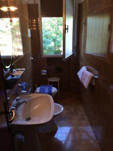 a bathroom with a sink and a toilet and a window at Locanda Irene in Monte San Pietro