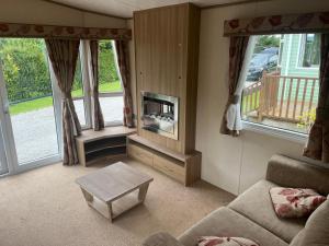 a living room with a couch and a fireplace at Natland Caravan Park in Kendal
