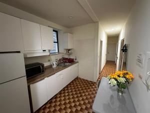 a kitchen with white cabinets and a table with flowers on it at Hudson Yard 408 in New York