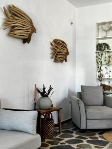uma sala de estar com um sofá, uma cadeira e uma mesa em Εvi Evan Hotel em Galissas