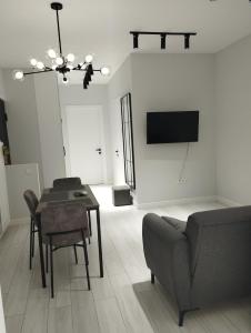 a living room with a table and a couch and a television at Tina's home in Batumi