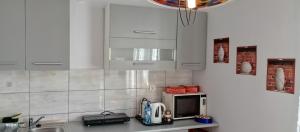 a kitchen with white cabinets and a microwave at U Magdy apartament dla 4 osób 2 par parking w cenie samodzielne zameldowanie klucze w skrytce kod wysyłany przed przyjazdem in Borne Sulinowo