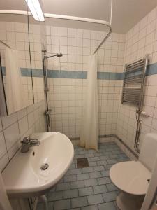 a white bathroom with a sink and a toilet at Home Inn DRV278 in Stockholm