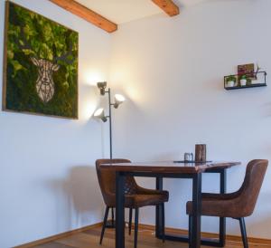 a dining room table with chairs and a painting at swissme - modernes Studio mit Balkon & Parkplatz & Netflix in St. Moritz