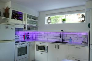 a kitchen with purple tiles on the wall at The Kalamoir Suite in West Kelowna