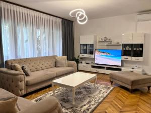a living room with a couch and a tv at Riverside Resort Una in Bihać