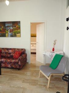 un soggiorno con divano e sedia di Stanze Ad Est a Ragusa