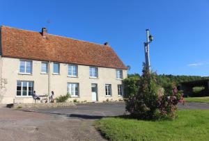 a person sitting on a bench in front of a building at Le Petit Luquis - maison de campagne 7 chambres - in Chézy-sur-Marne