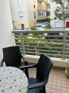 deux chaises et une table sur un balcon dans l'établissement Charmant appartement à 5 min de la plage bouznika, à Bouznika
