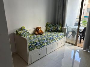 - un ours en peluche assis sur un lit dans une pièce dans l'établissement Charmant appartement à 5 min de la plage bouznika, à Bouznika