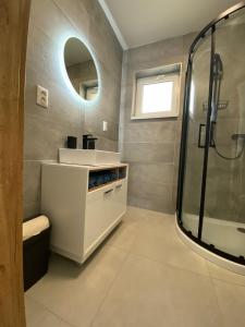 y baño con lavabo y ducha. en Šírava Resort, en Klokočov