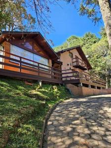 a large house with a walkway in front of it at Lareira forno e fogao a lenha nas montanhas in Camanducaia