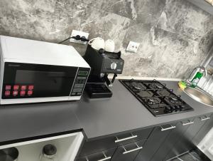 a kitchen counter with a microwave and a stove at Apartament HD3 in Hunedoara