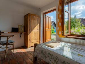 a bedroom with a bed and a desk and a window at Lipowy dom in Piecki