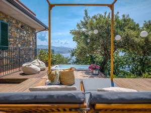 a wooden deck with two couches and a pool at Borgo Eleatico in Casal Velino
