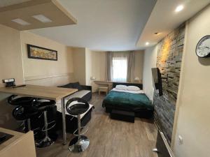 een kleine kamer met een bed, een tafel en een tv bij Apartments Konaci Kopaonik in Kopaonik