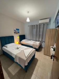 a bedroom with two beds and a window at Holiday House 3- Kallithea Halkidiki in Kallithea Halkidikis